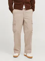 Pantalón cargo color beige de pierna ancha con fit amplio y tiro medio alto. Cuenta con bolsillos delanteros, traseros y laterales, cierre con cremallera y puños doblados.