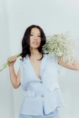 Chaleco color amarillo pastel de lino, sin mangas, con cuello solapa y cierre frontal con dos botones.