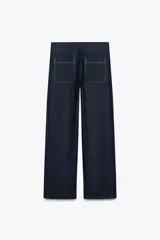 Pantalón de lino color azul marino, de tiro medio, corte recto y bolsillos delanteros y traseros. Presenta pespuntes a contraste en color blanco.