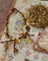 Collar corto con cordón de algodón color menta y flores de bronce.