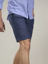 Bermuda color beige claro, de corte casual y largo por encima de la rodilla, con bolsillos laterales.