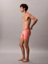 Pack de tres bóxer brief Calvin Klein, confeccionados en mezcla de poliéster y elastano. Incluyen cintura elástica con el logo distintivo de la marca. El pack incluye un bóxer rojo liso, uno rosa liso y uno gris a rayas horizontales.