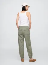 Pantalón jogger verde militar con bolsillos laterales y tobillos ajustados con elástico.