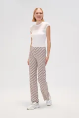 Pantalón largo de poliéster con estampado de rayas diagonales en tonos beige y marrón, de corte recto y tiro medio.