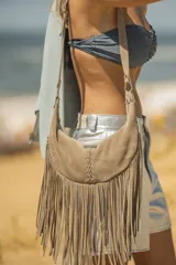 Bandolera de gamuza color marrón chocolate, con flecos largos y logo de la marca Pecari.