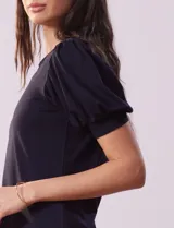 Remera blanca de modal con cuello redondo y mangas cortas abullonadas con puño.