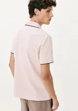 Camisa polo color rosa claro con cuello clásico, tapeta de dos botones y bordado de logo en el pecho. Presenta ribete azul marino en cuello y mangas. Corte clásico.