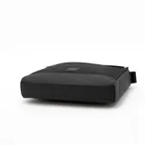 Bolso tipo mensajero o bandolera de color negro, con cuerpo principal de tela y base de material sintético liso. Presenta un bolsillo frontal con cierre metálico y un parche pequeño con el logo de Calvin Klein. Incluye una correa ajustable de tela negra.