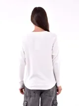 Buzo negro de tejido de punto con cuello redondo y mangas largas, decorado con apliques de strass en el canesú.