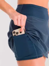 Falda deportiva negra con calza interior y bolsillo lateral. Diseño cruzado en la parte frontal.