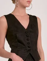 Chaleco color beige de estilo formal, con escote en V y cierre frontal de botones. Presenta bolsillos falsos a la altura de la cintura.