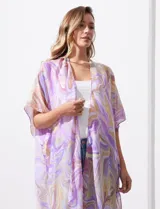 Kimono tejido con estampado abstracto en tonos verde, azul y blanco. Tiene mangas cortas amplias y terminación con borlas verdes en el ruedo.