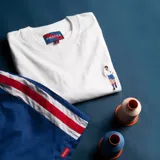 Remera blanca de algodón de alto gramaje con bordado en el pecho de un jugador de fútbol.