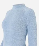Suéter de punto color blanco, con cuello alto y mangas largas, confeccionado en tejido de peluche.