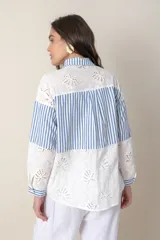Camisa blanca de algodón con bordado calado y rayas celestes.