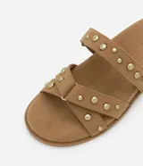 Sandalias planas color marrón claro con efecto gamuza y dos tiras con tachas doradas.