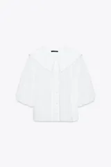 Camisa blanca de popelín con cuello bobo y mangas abullonadas 3/4. Cierre frontal con botones.