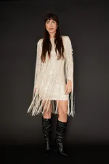 Minivestido color champagne con lentejuelas y flecos largos.