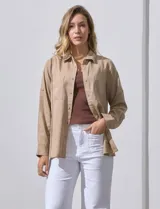 Camisa color beige de lyocell, marca Dash. Tiene cuello con solapa, abertura central con botones, mangas largas regulables con presilla y botón, y bolsillos aplicados en la parte delantera.