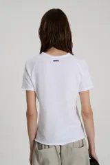 Remera de jersey flamé de algodón con escote redondo y manga corta tipo ranglan, con detalles de ruedos cortados y bordado a tono en el frente.