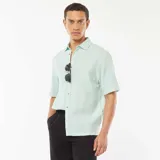 Camisa verde de manga corta con cuello clásico y cierre con botones.