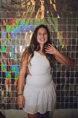 Vestido corto blanco con un hombro descubierto, pieza fruncida en la espalda, cut out en cintura y espalda con top y pollera separados. Falda con corte en caderín y volado, y un bretel fino que se cruza en la espalda.
