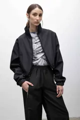 Campera cropped de inspiración deportiva, color azul marino, con cuello alto, cierre frontal a tono, bolsillos funcionales y puños elastizados. Confeccionada en tela campera repelente al agua, con interior de micropolar.