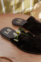 Sandalias tipo mule de cuero color marrón chocolate, con diseño de tiras anchas cruzadas y suela plana.