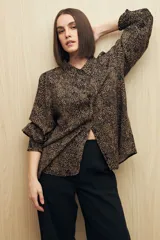 Camisa marrón con estampado animal print, cuello clásico, abotonadura frontal y mangas largas con puños elastizados.