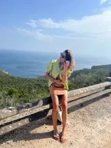 Camisa color ladrillo confeccionada en lino, con cuello mao, mangas cortas abullonadas y cierre frontal con botones.