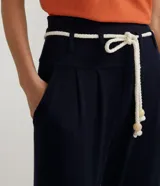 Pantalón tipo jogger azul marino de viscosa y elastano, con cintura ancha, trabillas y cinturón de cuerda con cuentas de madera.