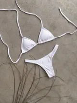 Conjunto de bikini verde esmeralda, con corpiño triangular de atar al cuello y espalda, con almohadillas desmontables, y bombacha colaless con laterales fijos.