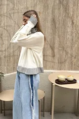 Sweater color borgoña de tejido de punto con cuello alto y terminaciones acanaladas en color crema.