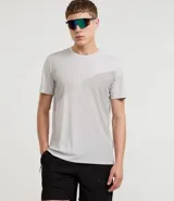 Remera deportiva de hombre, manga corta y cuello redondo, color gris claro con un panel de tela gris más oscuro en el frente con efecto degradado.