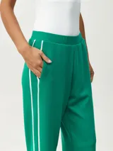 Pantalón blanco de corte ancho con una fina línea negra vertical en los laterales.