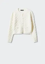 Cárdigan color crema con textura de punto, cuello redondo, cierre frontal con botones y bolsillos frontales decorativos. Corte cropped y mangas largas.