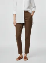 Pantalón de vestir color marrón oscuro, corte recto y tiro medio, con bolsillos laterales y cierre de gancho.