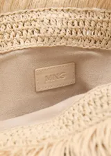 Bolso de mano tipo clutch color beige, tejido en fibra natural con flecos.