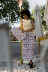 Falda midi blanca con lunares amarillos y bolsillos laterales.