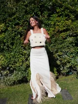 Top corto de corderito color crudo, con breteles y cierre con broches en la espalda. Decorado con pins y tachas variadas.