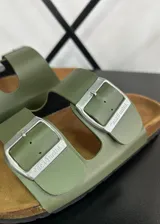 Sandalias de ecocuero color verde oliva con dos tiras ajustables con hebillas plateadas y plantilla anatómica de corcho.