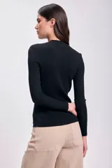 Remera negra de punto rib con cuello redondo y mangas largas.