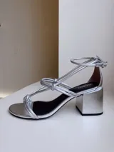 Sandalias negras de cuero con tiras finas con nudos en el empeine y pulsera con hebilla en el tobillo. Tacón bloque de 7cm.