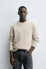 Sweater verde oscuro de punto, con cuello redondo y manga larga. Tejido en hilatura con mezcla de lana y acabados en rib.