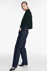 Pantalón de jean negro con corte recto, tiro medio, cinco bolsillos y detalle de banda lateral a contraste en color negro más oscuro.