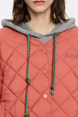 Cazadora corta acolchada de tejido técnico color ladrillo, con escote de pico redondeado, manga larga con volumen y cierre frontal con botones de presión. Incluye bolsillos con vivo, bajo ajustable con botones de presión y logo bordado.