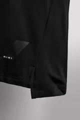 Camiseta deportiva verde militar confeccionada en tejido estructurado, ligero y elástico. Tiene cuello redondo, manga corta y bajo con aberturas laterales. Incluye logo estampado en el bajo.