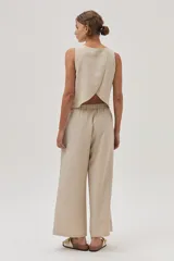 Pantalón de vestir color beige, de corte ancho y tiro alto, con cintura elástica ajustable con cordón.