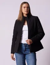 Campera negra capitoneada marca Gallery, con cierre central, bolsillos frontales con cierre, cintura con cinto de ajuste regulable y forro interno a tono.