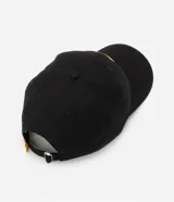 Gorra negra de sarga de algodón con visera curva, hebilla ajustable y logo de Kodak bordado en amarillo y rojo.